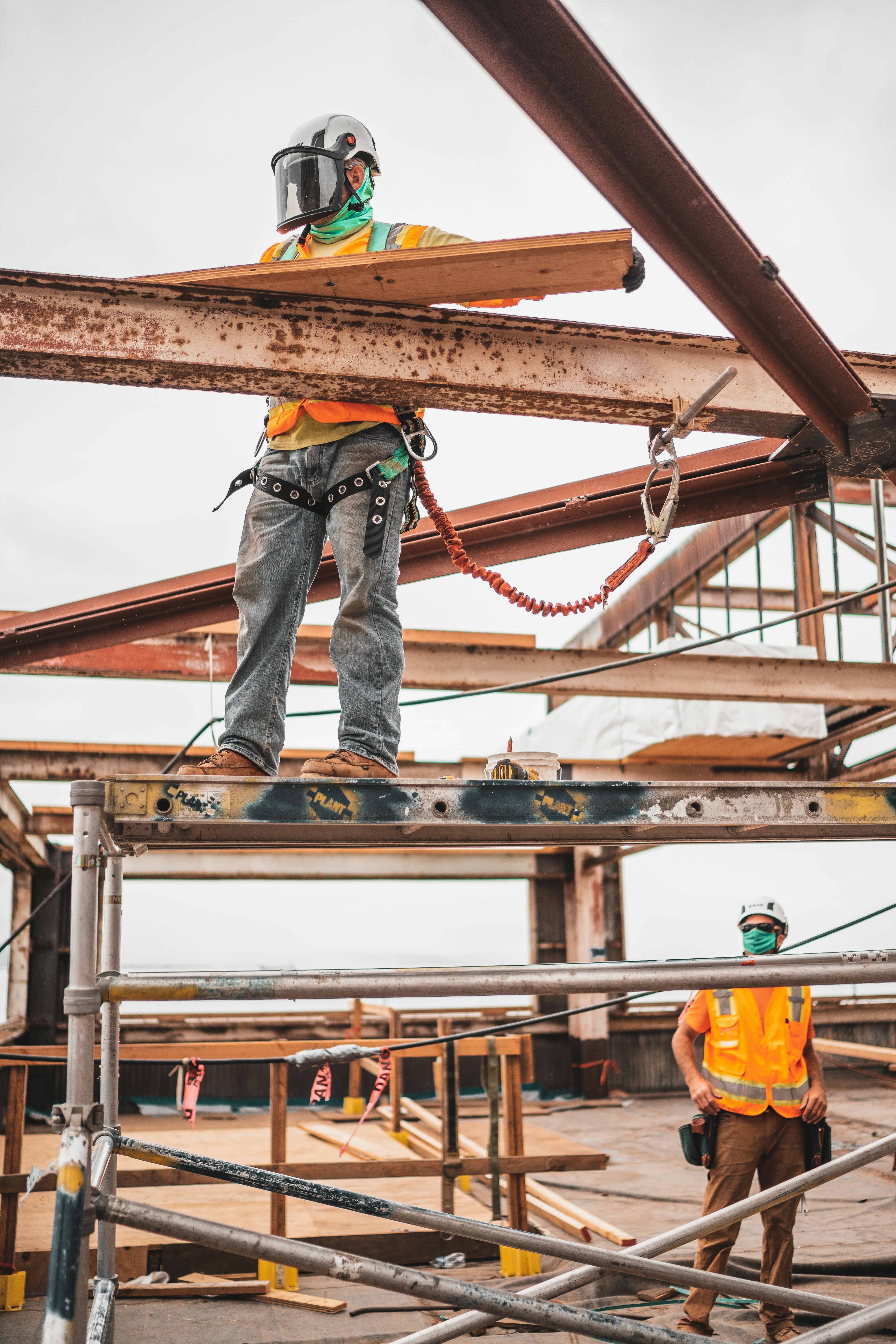 jeriden-villegas-niSnhfMjiMI-unsplash A construction worker standing on a platform holding a steel beam. This shows that workers of all industries will be impacted by the Employment Rights Bill